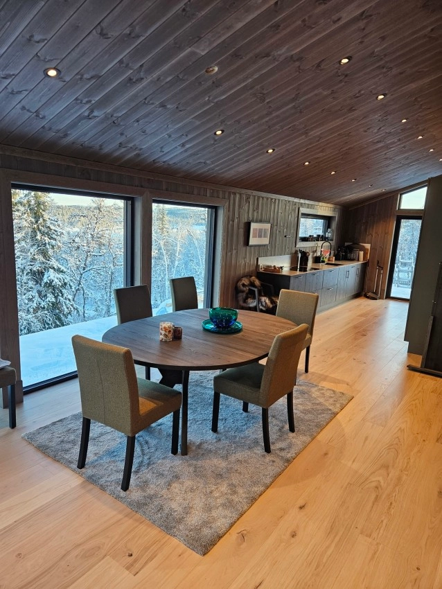 Spisestue på hytte med store vinduer og utsikt
